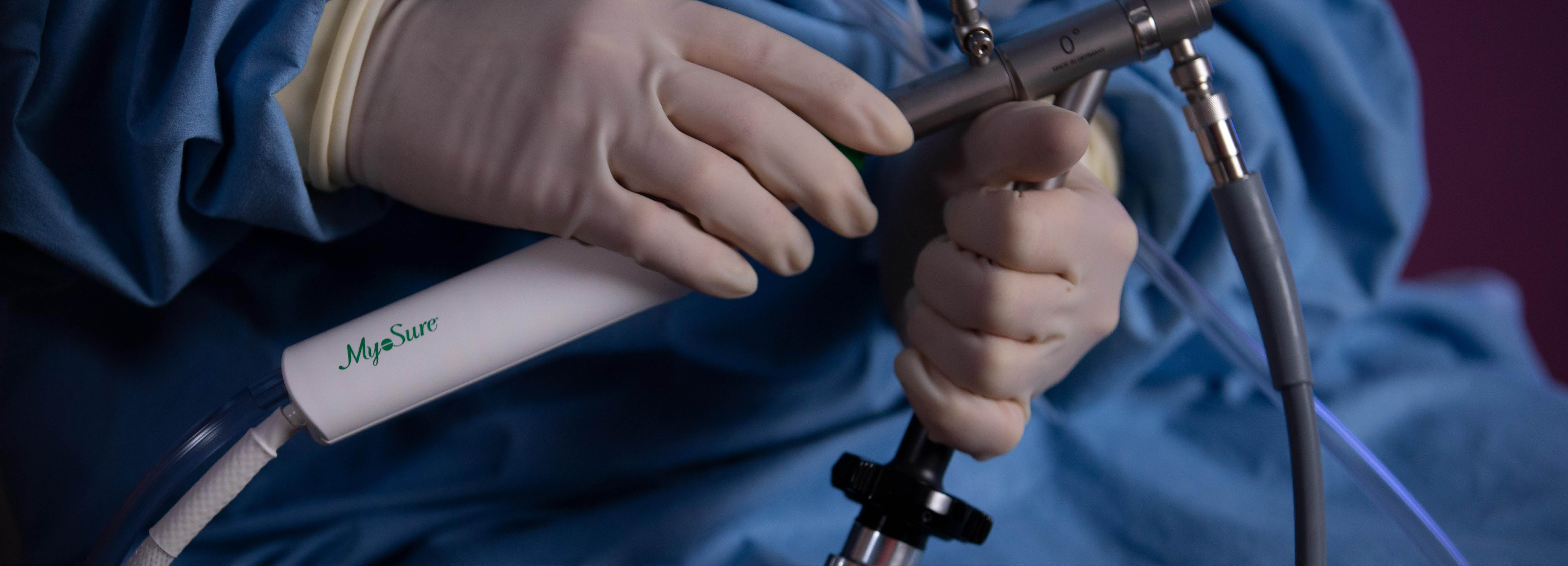 Manos con guantes sosteniendo un instrumento médico