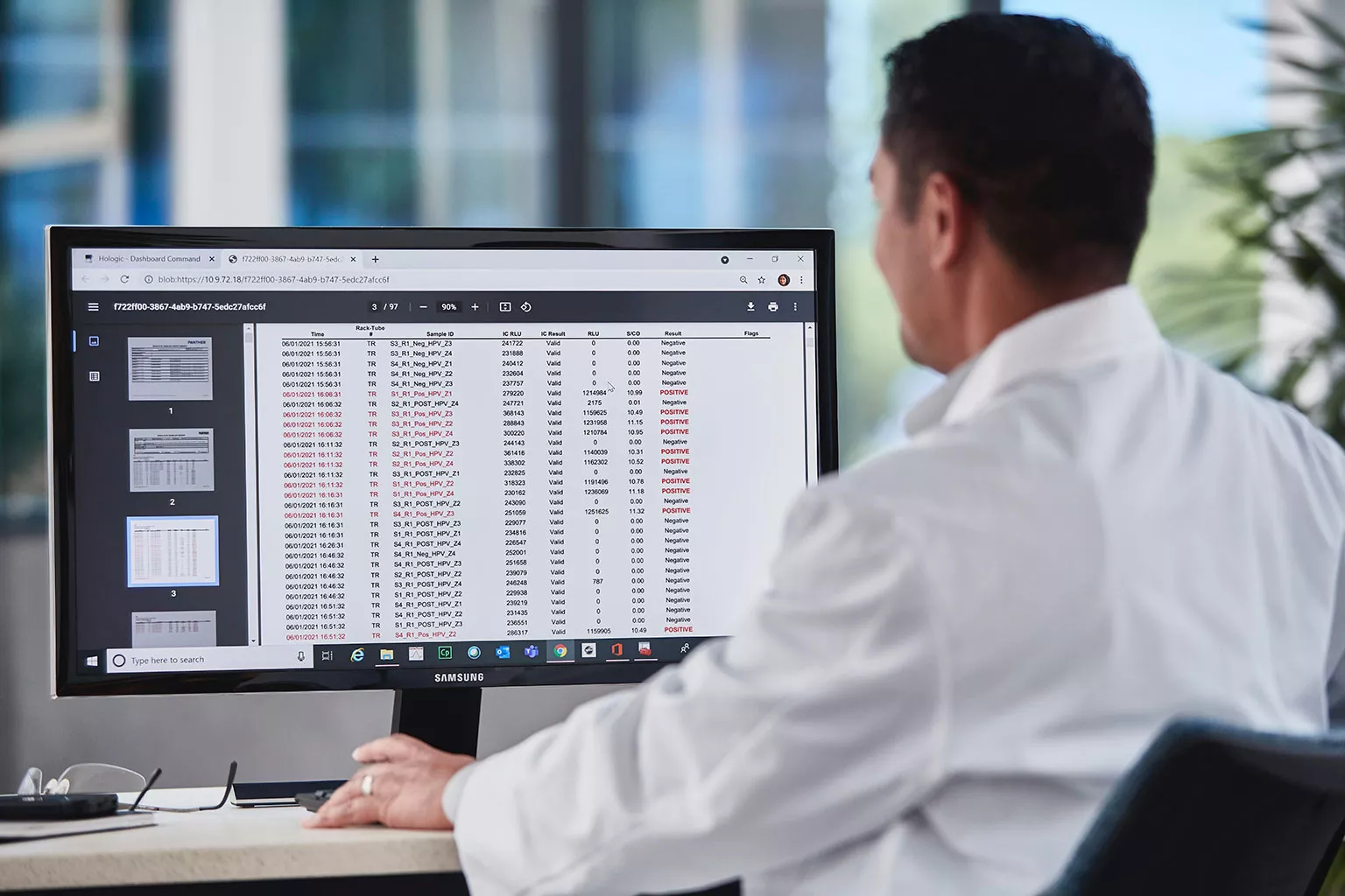 Técnico de laboratorio revisando datos de una pantalla en un laboratorio.