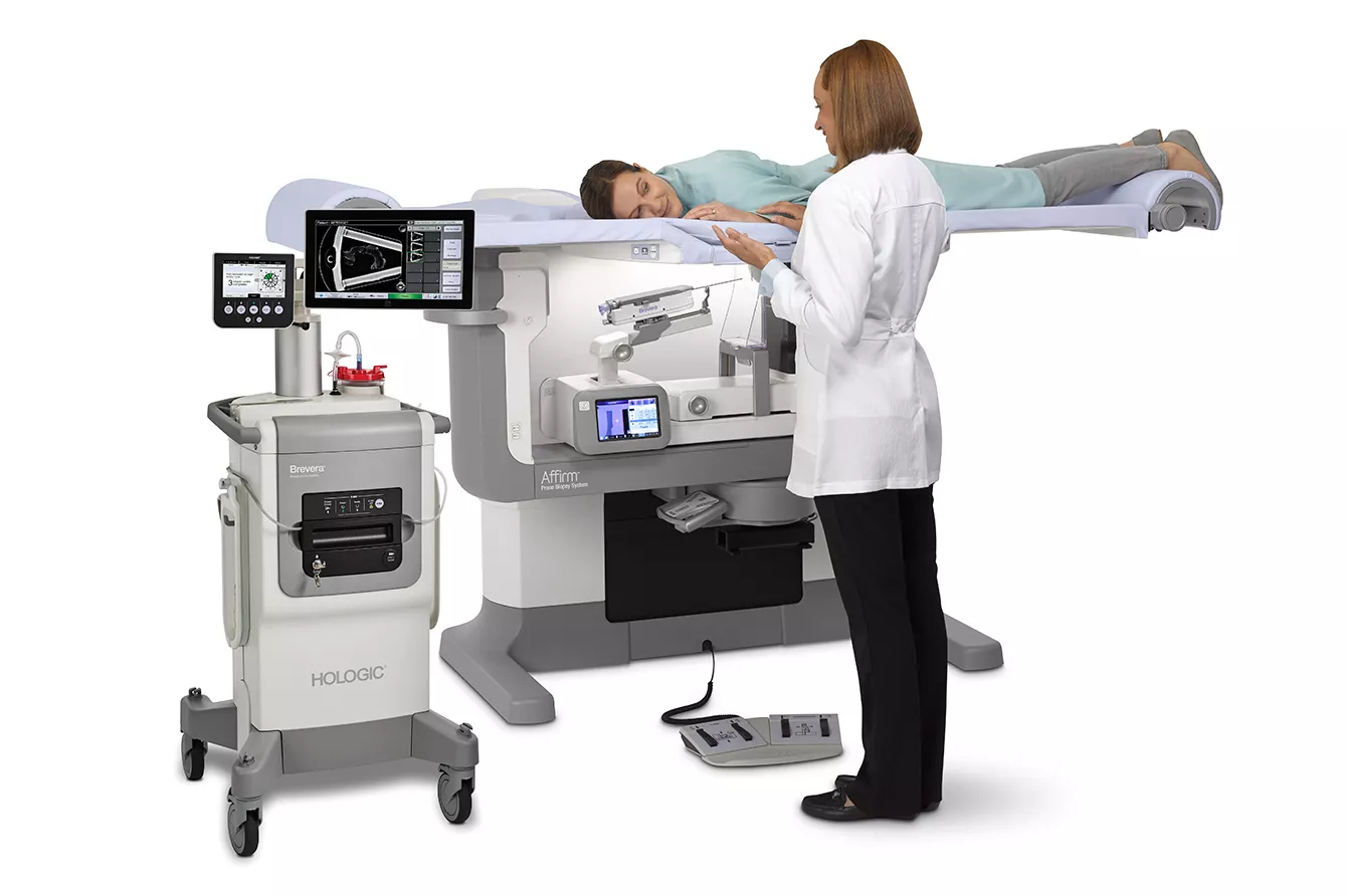 Paciente durante un procedimiento de biopsia de mama junto a un profesional sanitario