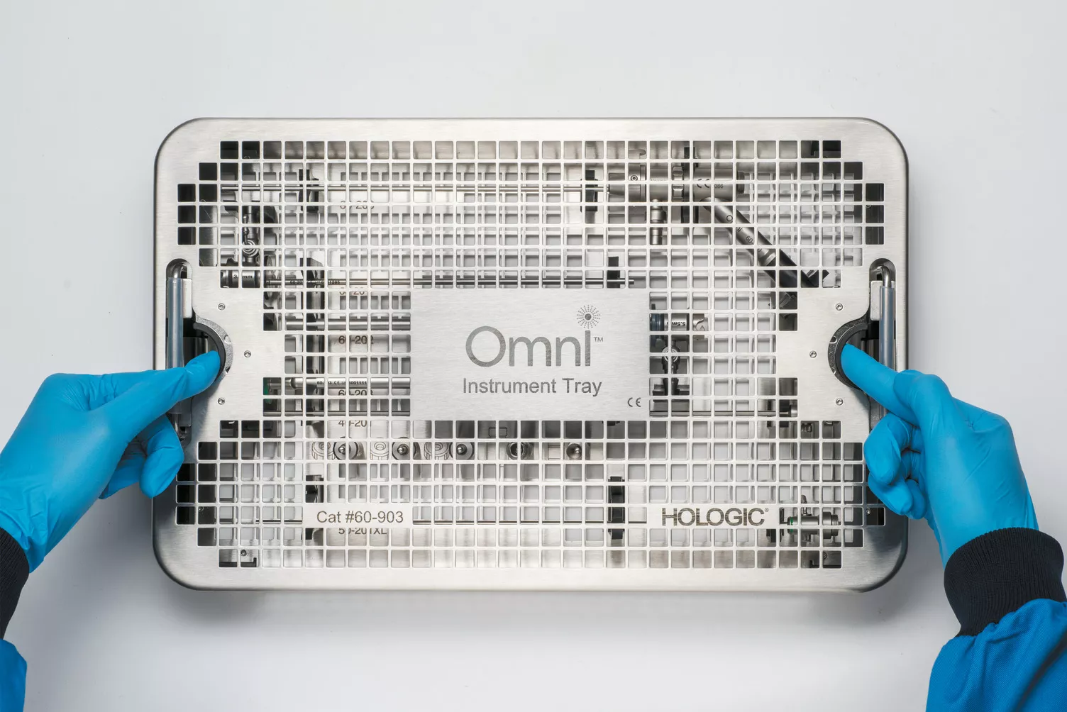 Manos con guantes trabajando con la bandeja médica sobre una mesa.