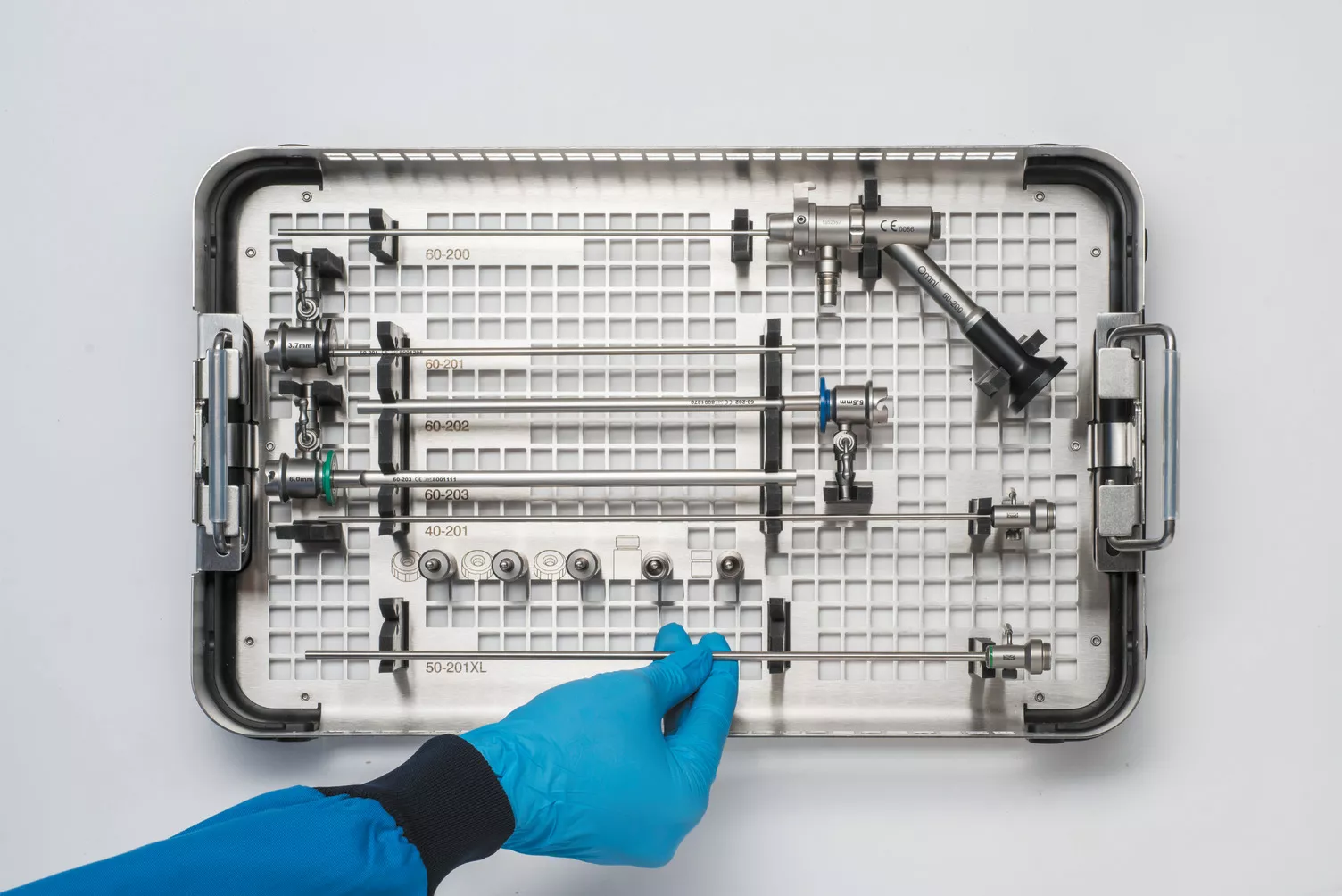 Mano con guante trabajando con la bandeja médica sobre una mesa.