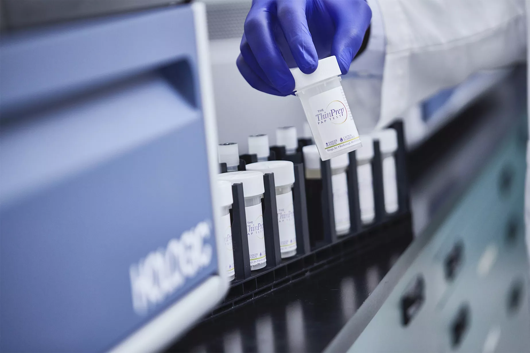 Mano con guante sosteniendo un vial